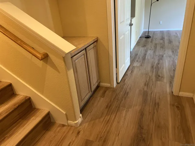 a view of a hallway with wooden floor and staircase