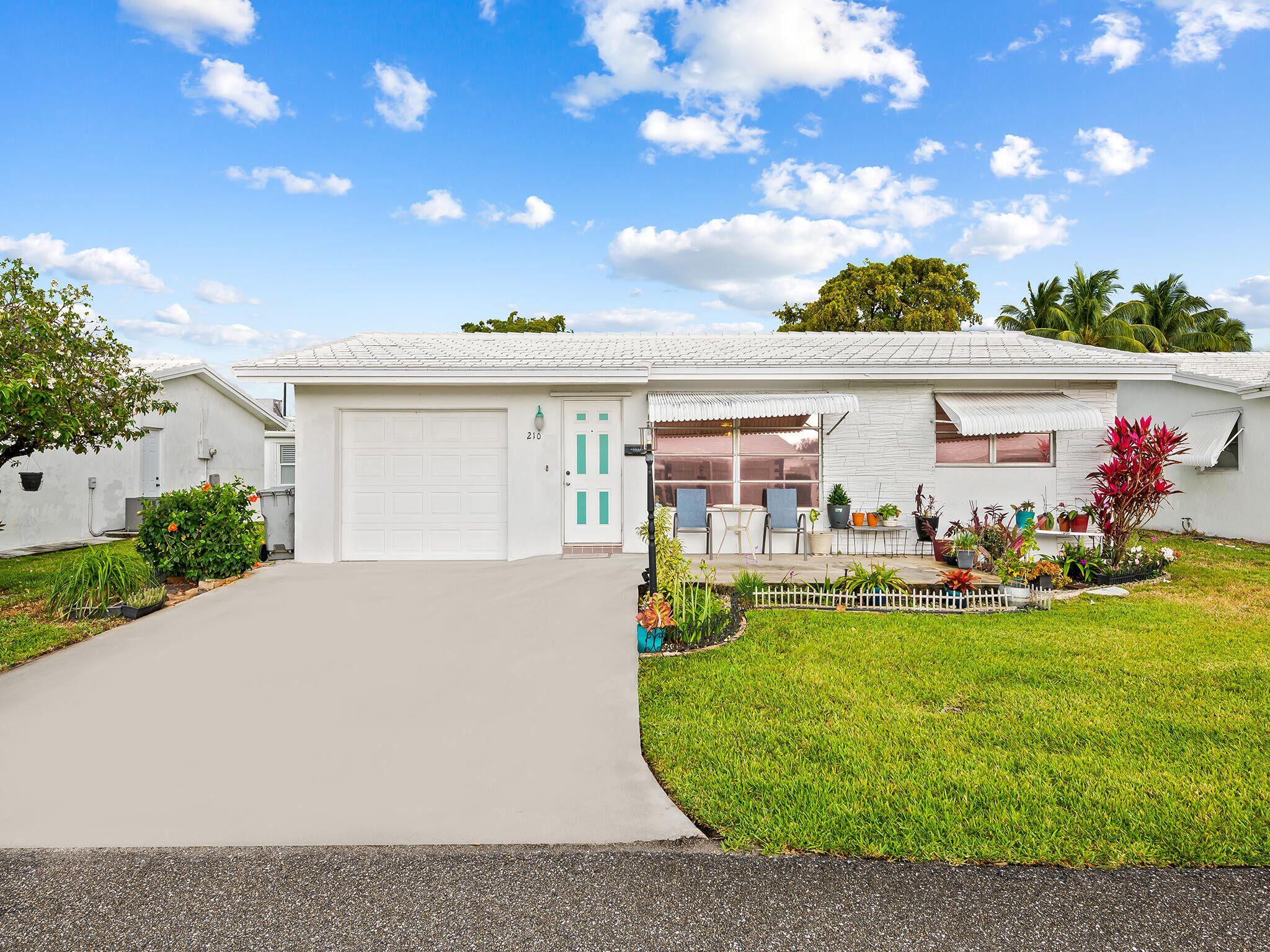 210 Northwest 25th Court Pompano Beach, FL 33064 - Photo 1 of 17 a view of a house with a yard and sitting area