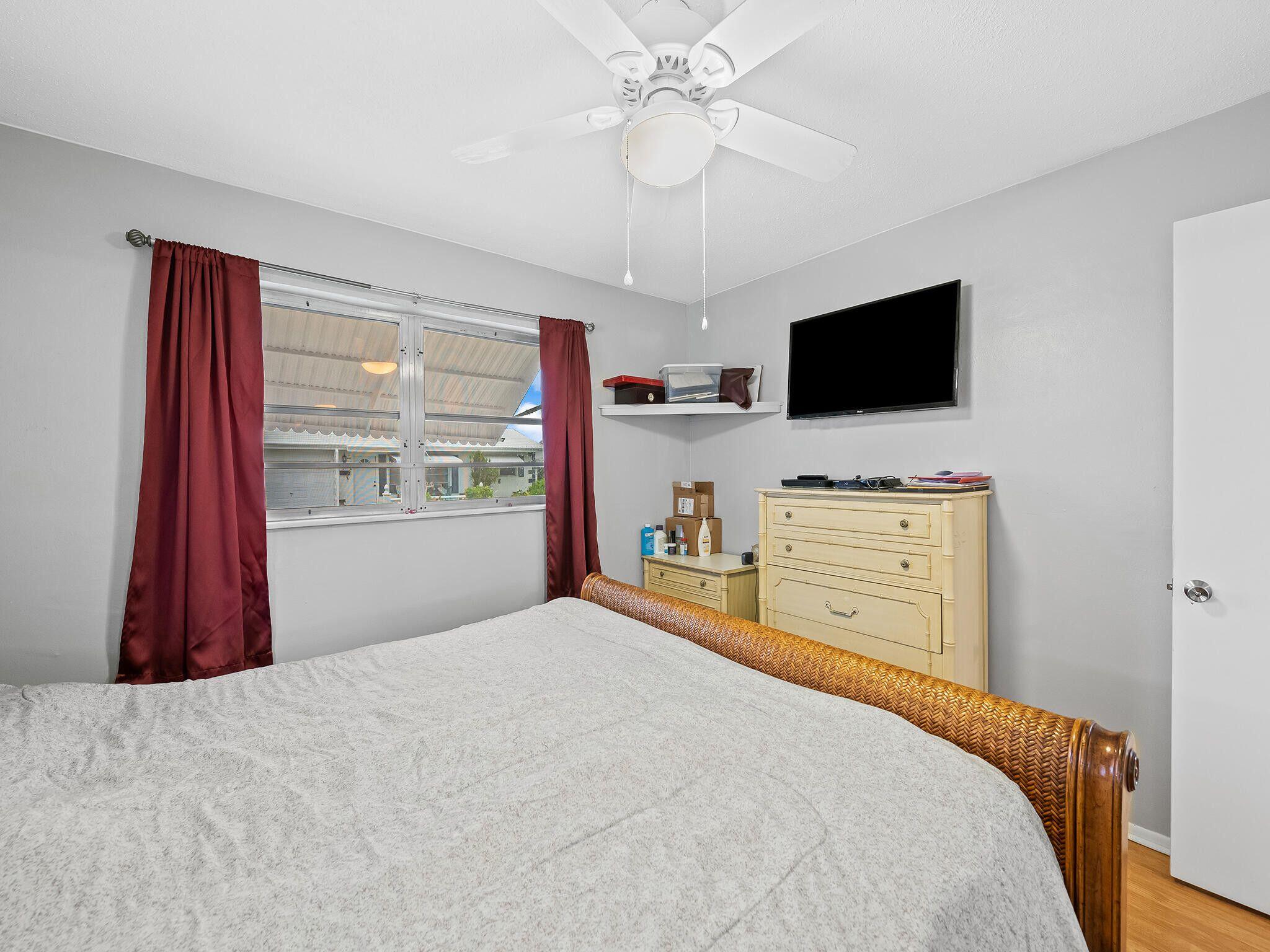 210 Northwest 25th Court Pompano Beach, FL 33064 - Photo 13 of 17 a bedroom with a bed and a flat screen tv