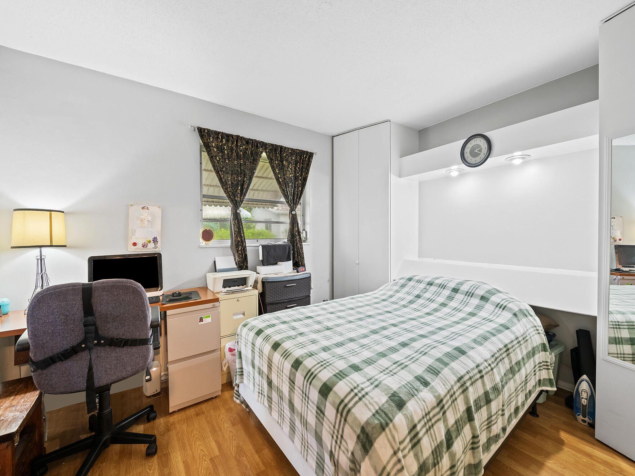 210 Northwest 25th Court Pompano Beach, FL 33064 - Photo 15 of 17 a bedroom with a bed and a large window