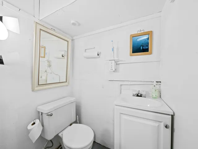 a bathroom with a toilet sink and mirror