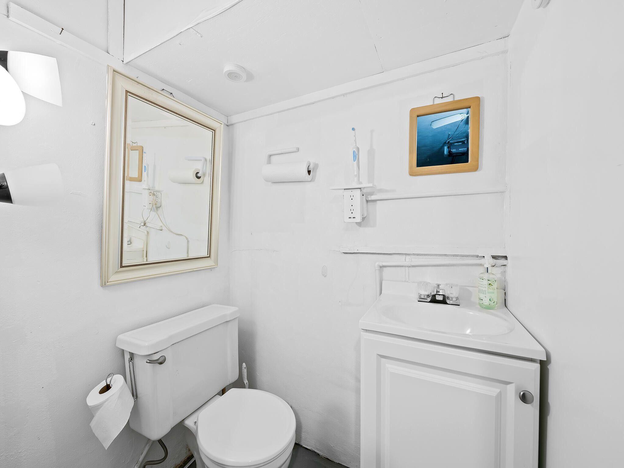 210 Northwest 25th Court Pompano Beach, FL 33064 - Photo 16 of 17 a bathroom with a toilet sink and mirror