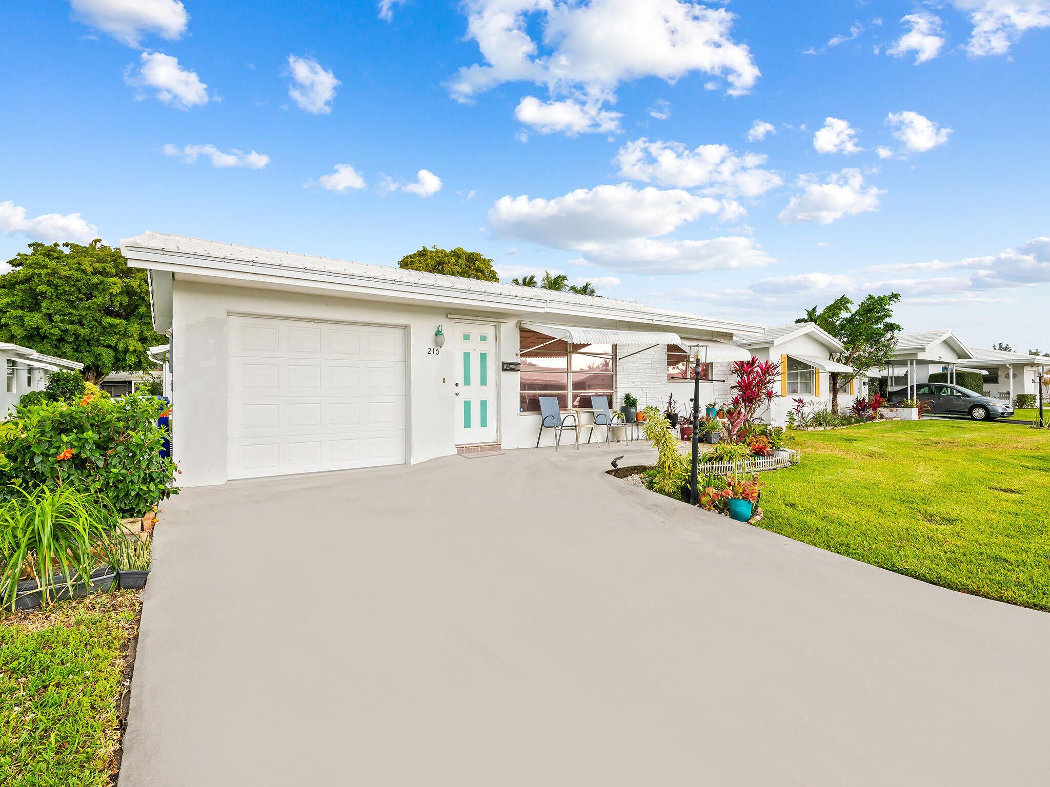 210 Northwest 25th Court Pompano Beach, FL 33064 - Photo 2 of 17 a view of a house with a yard and garage