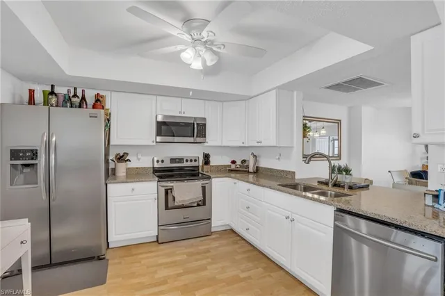 a kitchen with a sink stainless steel appliances and white cabinets