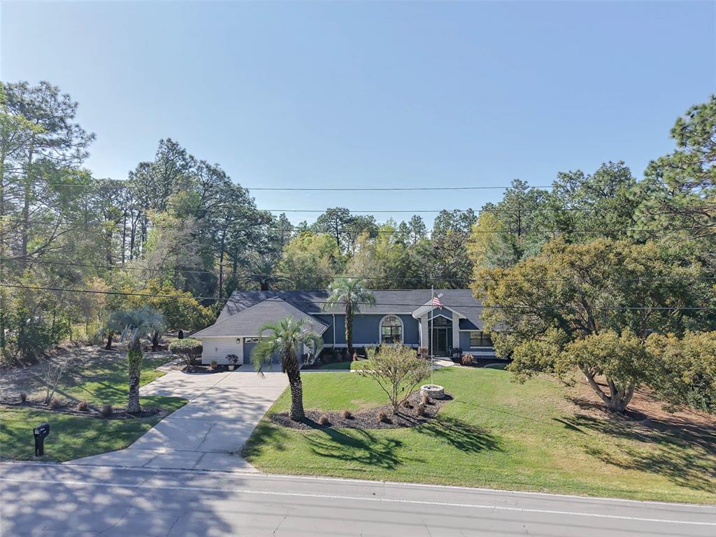 2298 West Pine Ridge Boulevard Beverly Hills, FL 34465 - Photo 1 of 34 a front view of a house with a yard