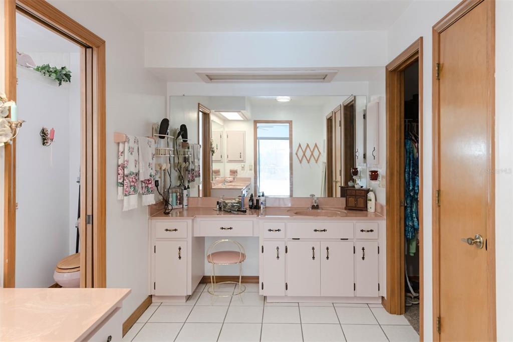 2298 West Pine Ridge Boulevard Beverly Hills, FL 34465 - Photo 21 of 34 a spacious bathroom with a double vanity sink a mirror a bathtub and next to a window