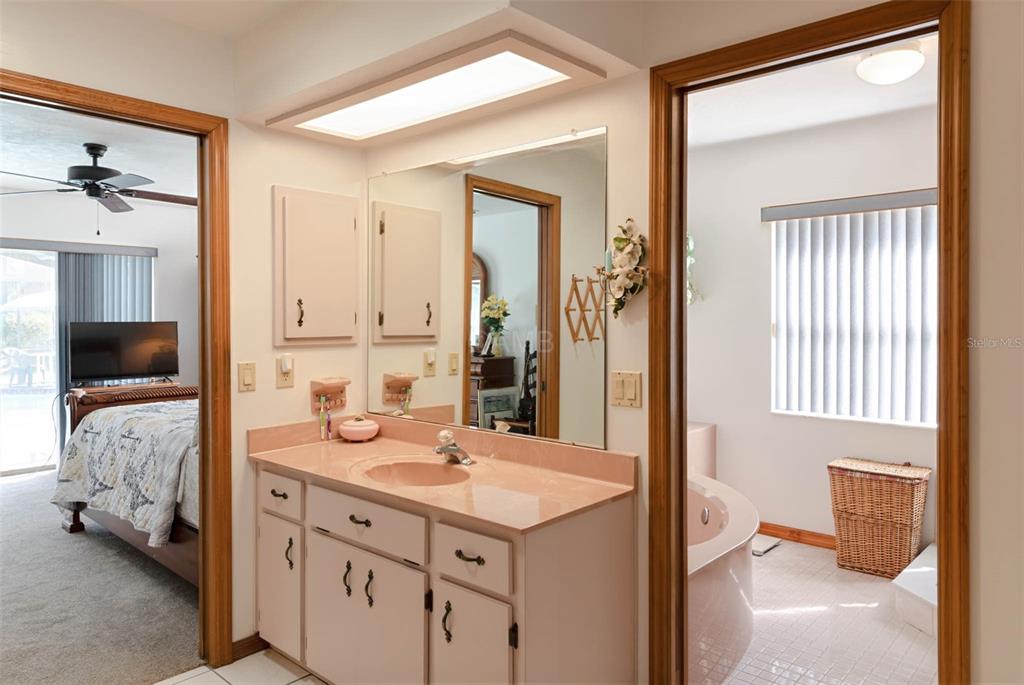 2298 West Pine Ridge Boulevard Beverly Hills, FL 34465 - Photo 22 of 34 a en suite bathroom with a double vanity sink and a mirror