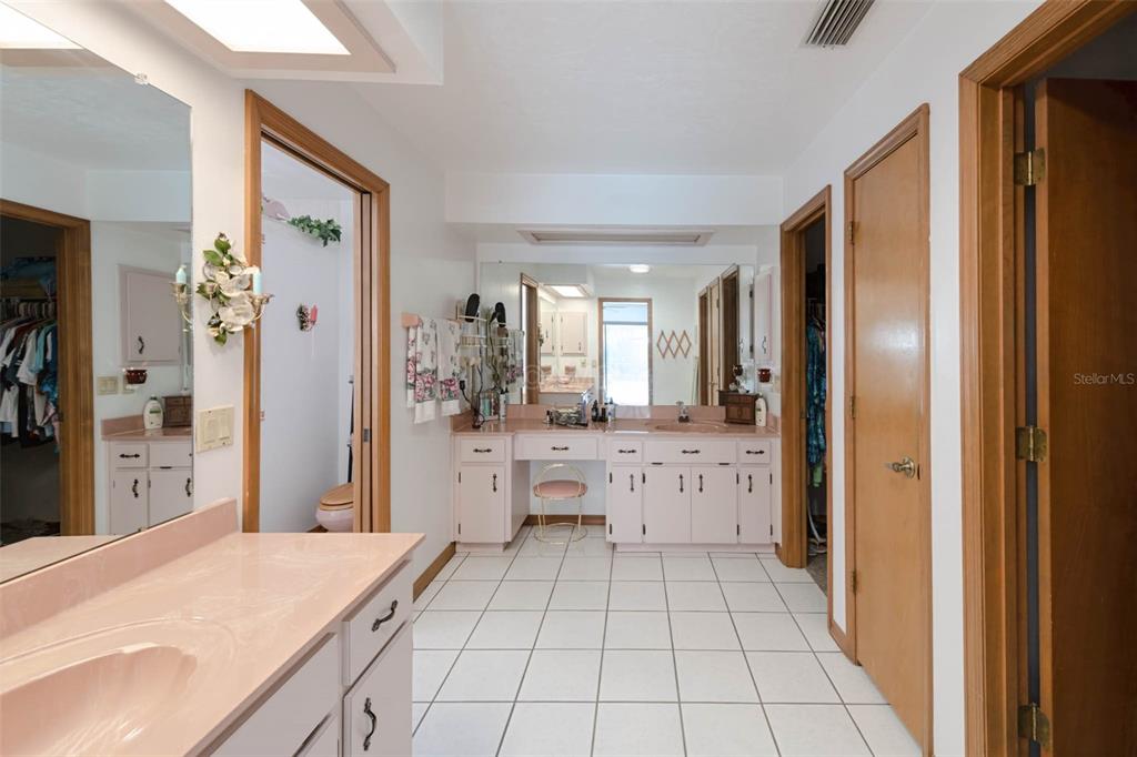 2298 West Pine Ridge Boulevard Beverly Hills, FL 34465 - Photo 23 of 34 a large white kitchen with a refrigerator a sink dishwasher and a large mirror