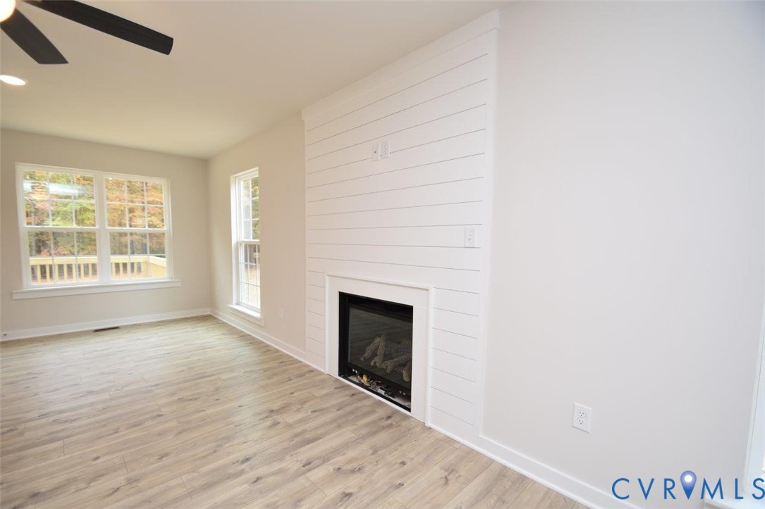 375 Amick Road Louisa, VA 23093 - Photo 14 of 25 an empty room with wooden floor fireplace and windows