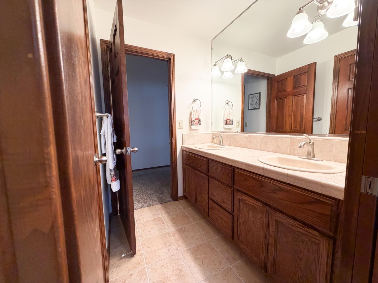 505 South Del Norte Avenue Kerman, CA 93630 - Photo 7 of 12 a spacious bathroom with a double vanity sink a mirror and a bathtub