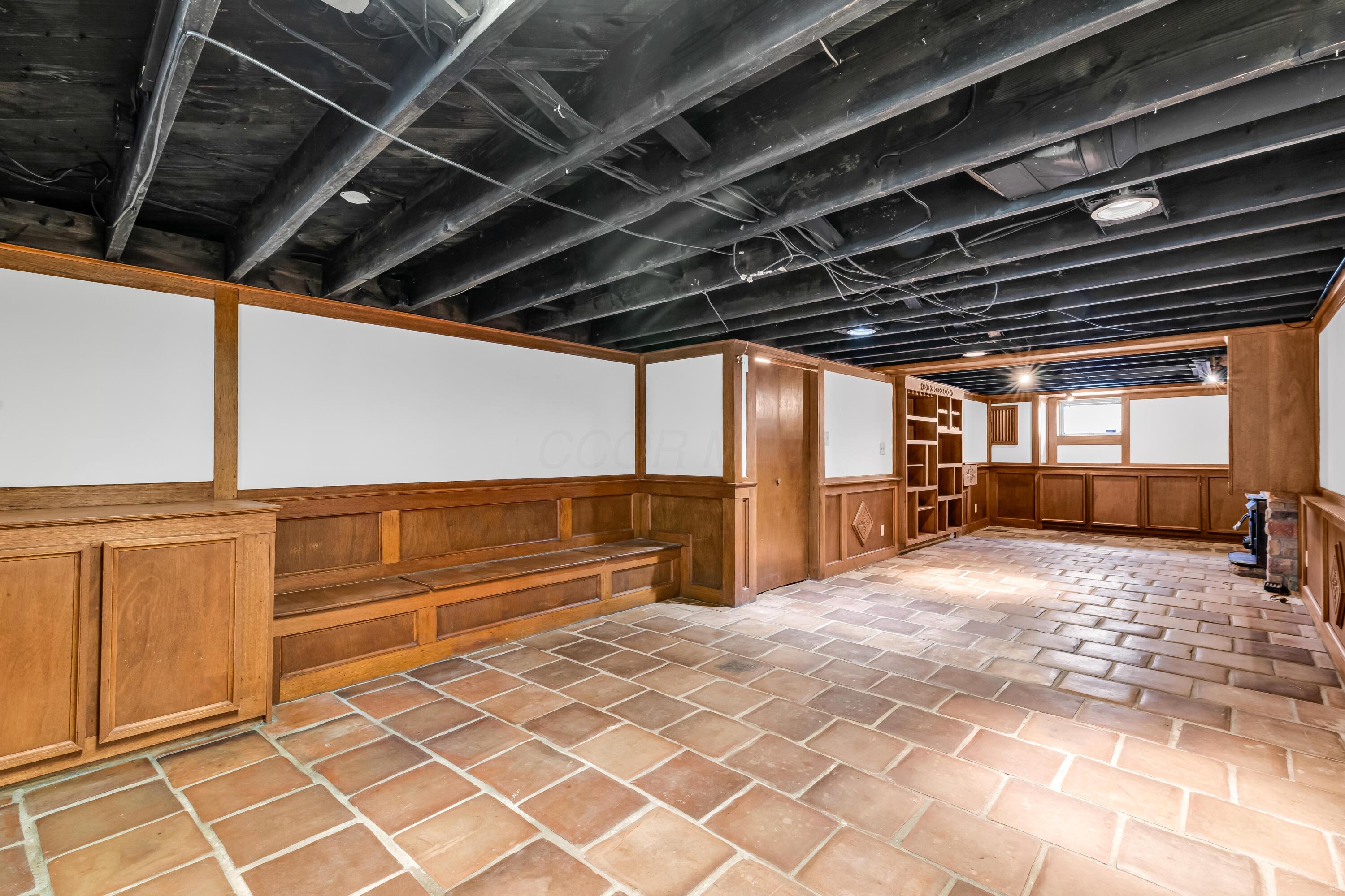2033 Zollinger Road Columbus, OH 43221 - Photo 25 of 44 • Ceramic tile flooring
• Ivory painted & wainscoted
walls
• Built-in seating & storage
• Can lighting
• Lighted cedar closet
• Stone fireplace with
woodburning insert
• Built-in bookcases
• Water meter access