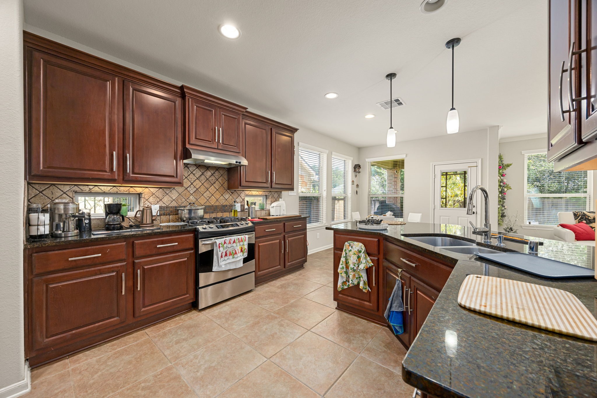 22 South Marshside Place Spring, TX 77389 - Photo 17 of 43 a kitchen with stainless steel appliances granite countertop wooden cabinets a stove top oven a sink and dishwasher