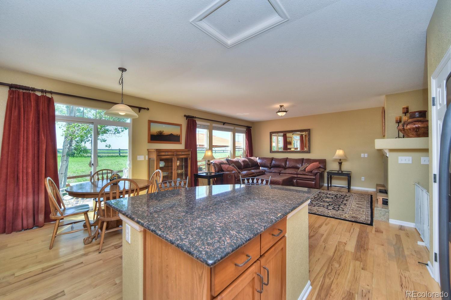 4464 Eagle River Run Broomfield, CO 80023 - Photo 11 of 32 a kitchen island with granite countertop dining room cabinets and wooden floor