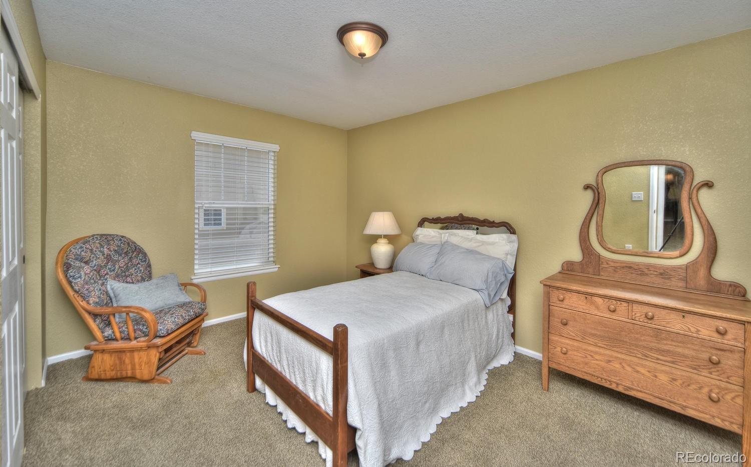 4464 Eagle River Run Broomfield, CO 80023 - Photo 21 of 32 a bedroom with bed and chair
