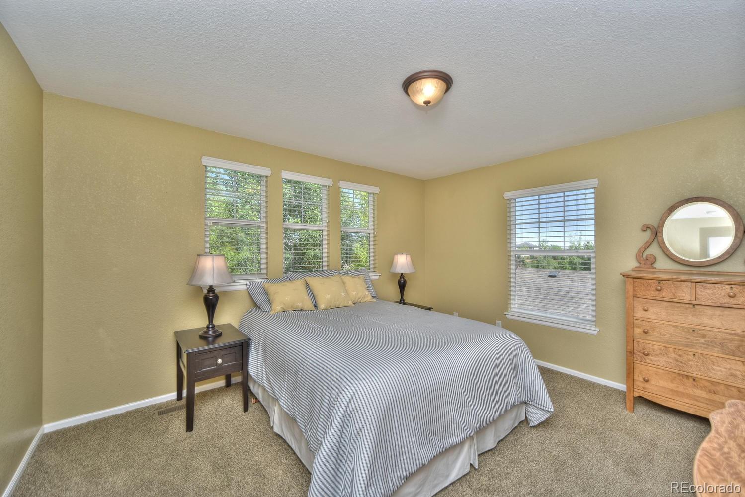4464 Eagle River Run Broomfield, CO 80023 - Photo 22 of 32 a bedroom with a bed and a dresser next to a window