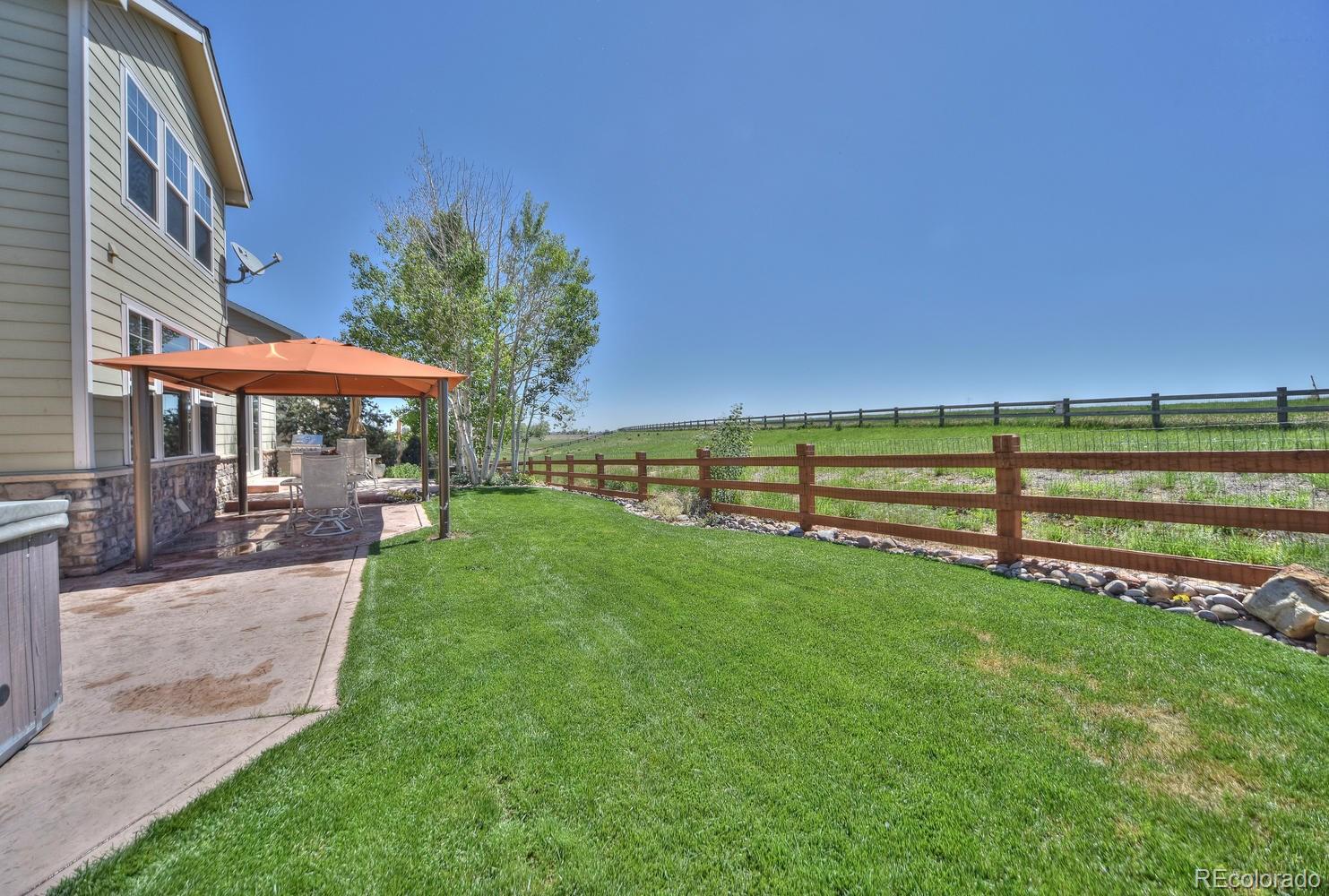 4464 Eagle River Run Broomfield, CO 80023 - Photo 26 of 32 a view of a table and chairs under an umbrella