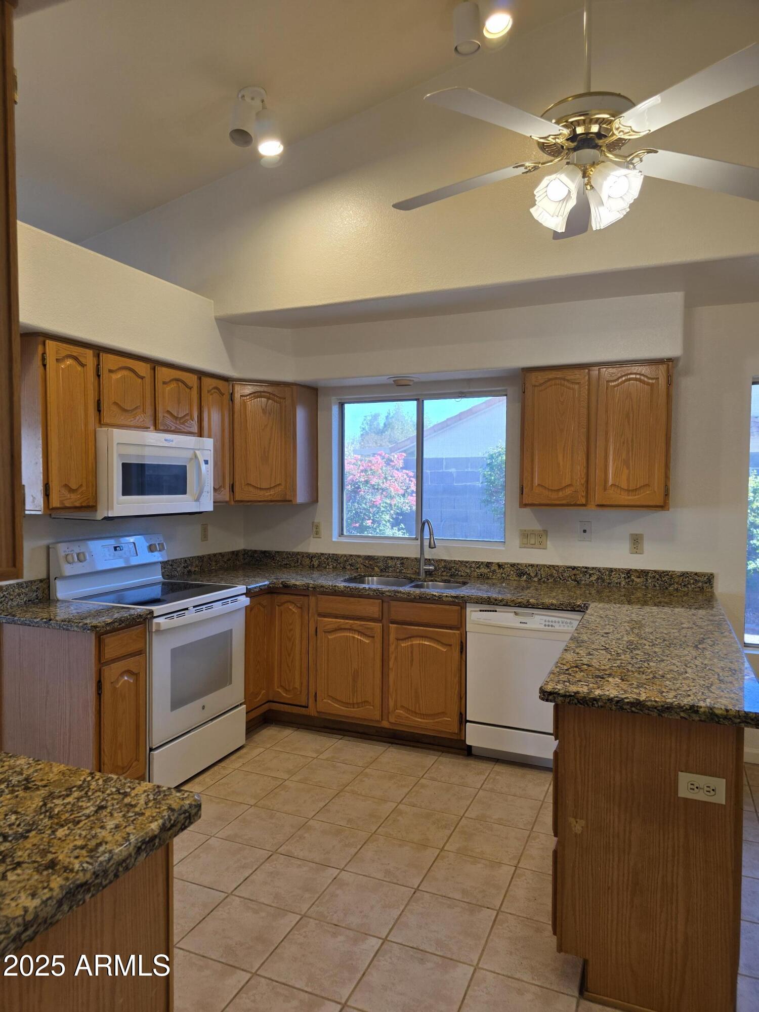 8758 West Bloomfield Road Peoria, AZ 85381 - Photo 3 of 20 a kitchen with stainless steel appliances granite countertop a stove a sink and a microwave