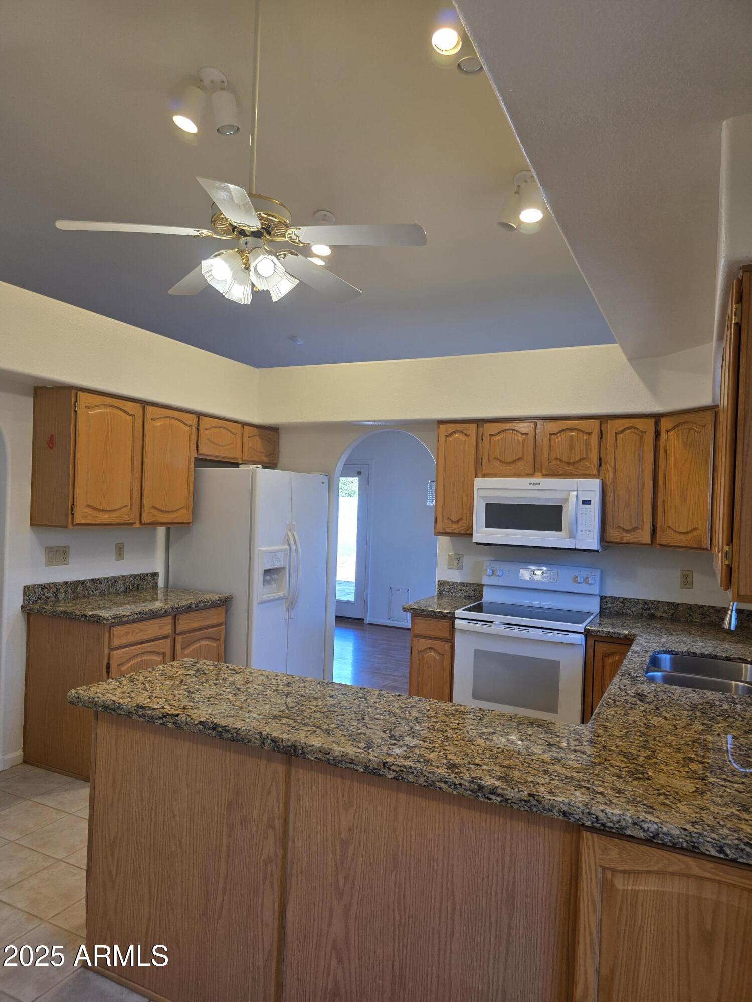 8758 West Bloomfield Road Peoria, AZ 85381 - Photo 5 of 20 a kitchen with stainless steel appliances granite countertop a sink a stove and a wooden cabinets