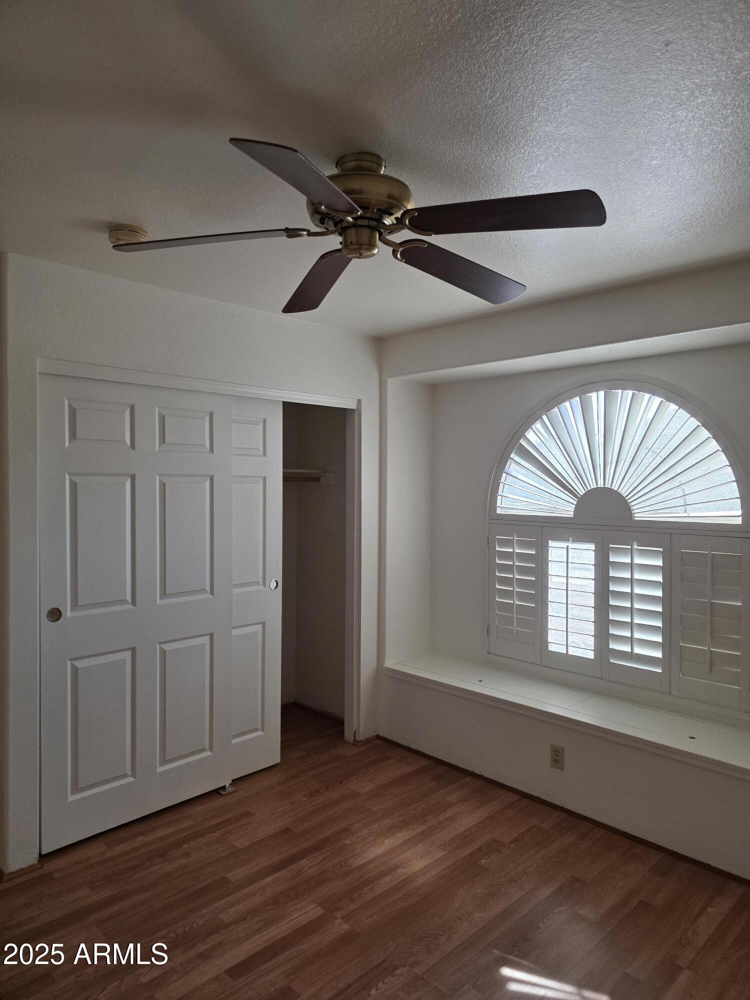 8758 West Bloomfield Road Peoria, AZ 85381 - Photo 9 of 20 a view of empty room with wooden floor and fan