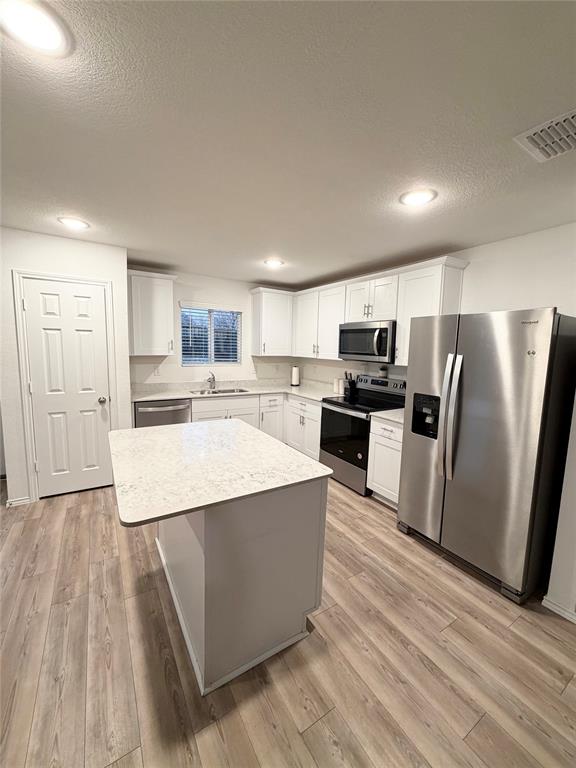 1129 Clear Dusk Lane Forney, TX 75126 - Photo 12 of 13 a large kitchen with stainless steel appliances granite countertop a large counter top a stove a refrigerator with white cabinets and wooden floor