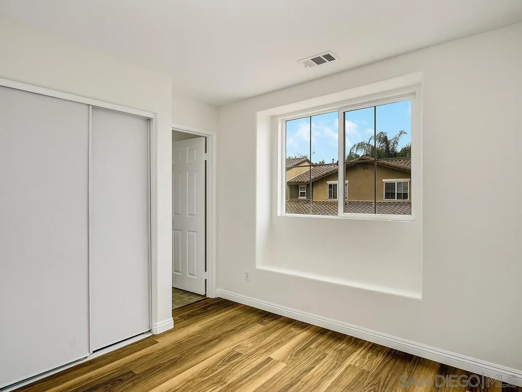 10214 Daybreak Lane, Unit 5 Santee, CA 92071 - Photo 25 of 38 a view of an empty room with wooden floor and a window