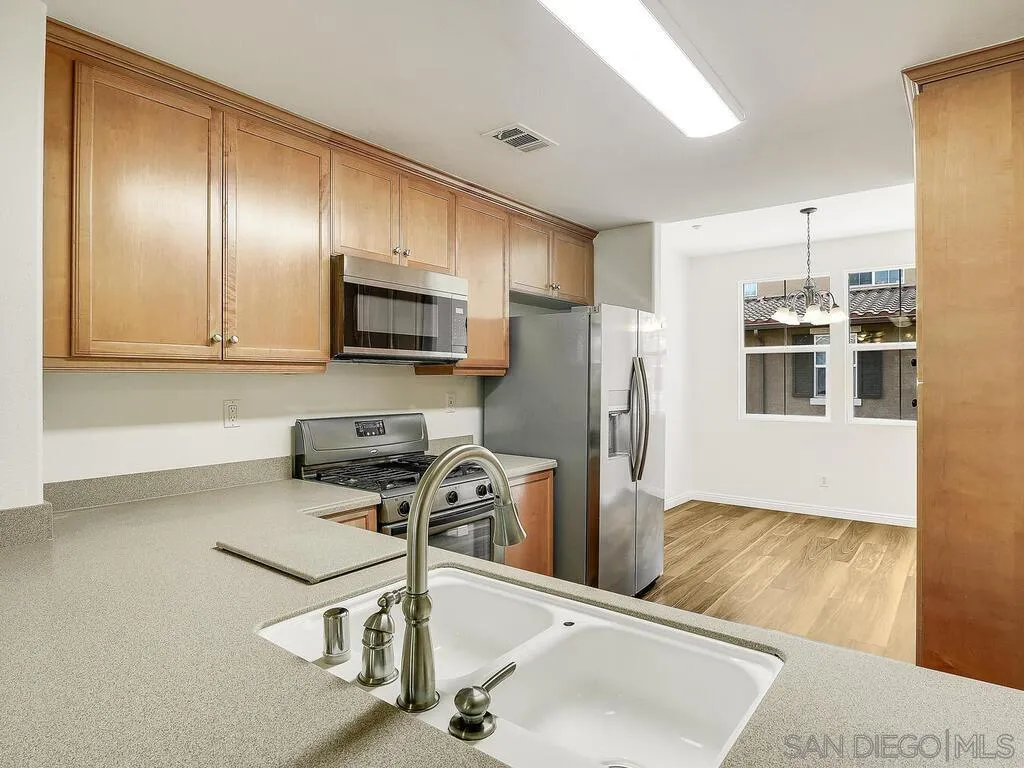 10214 Daybreak Lane, Unit 5 Santee, CA 92071 - Photo 9 of 38 a kitchen with stainless steel appliances granite countertop a sink refrigerator and microwave