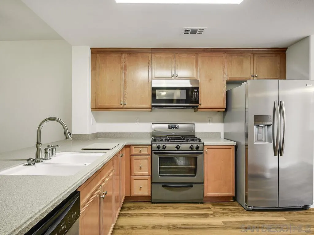 10214 Daybreak Lane, Unit 5 Santee, CA 92071 - Photo 10 of 38 a kitchen with stainless steel appliances a stove refrigerator sink and cabinets