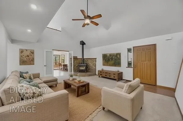 a living room with furniture ceiling fan and a window