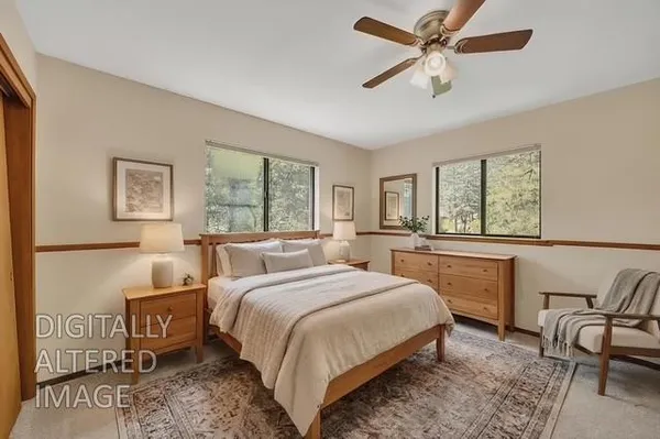 a bedroom with a large bed and windows