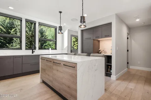 a kitchen with kitchen island granite countertop a stove a sink a center island and windows