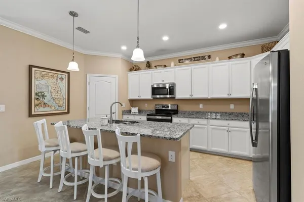 a kitchen with stainless steel appliances granite countertop a stove a sink island and a refrigerator