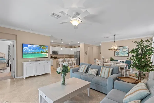 a living room with furniture a chandelier and a flat screen tv