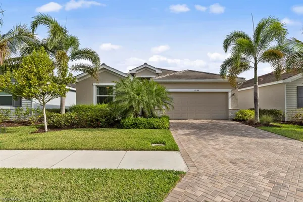 a front view of a house with a garden and palm trees