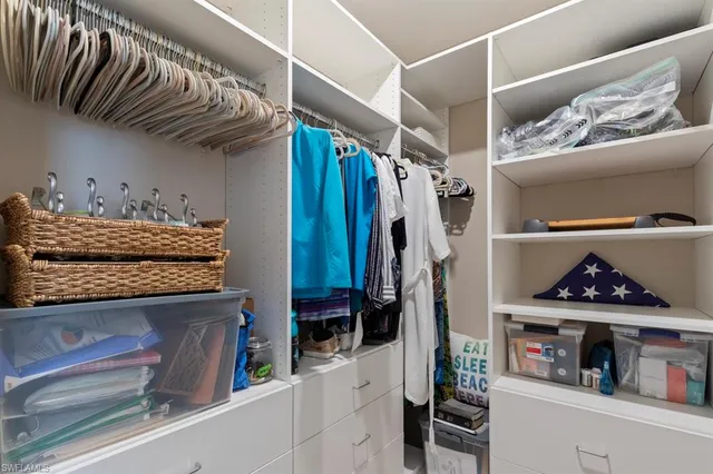 a view of walk in closet with clothes and shoes
