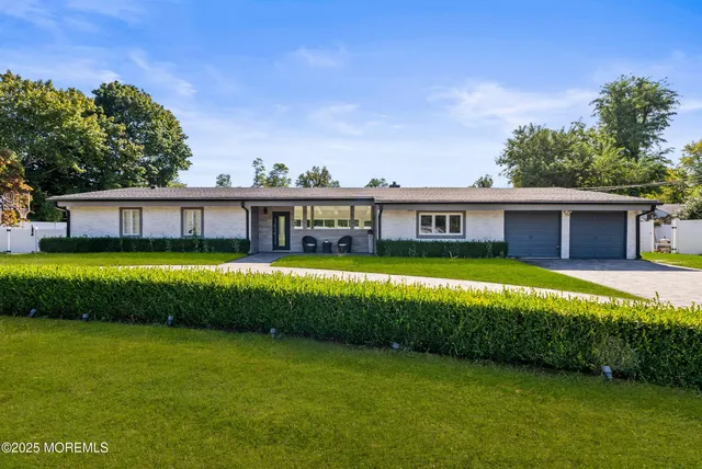 a view of a house with a big yard potted plants and large tree