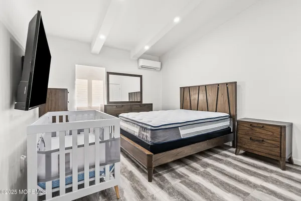 a bedroom with a bed window and a flat screen tv