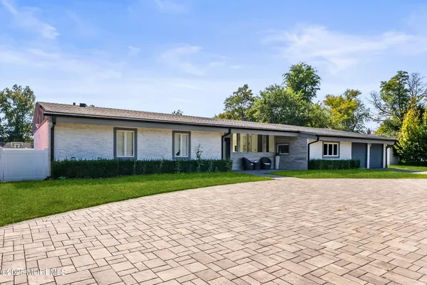 a front view of a house with a yard and trees