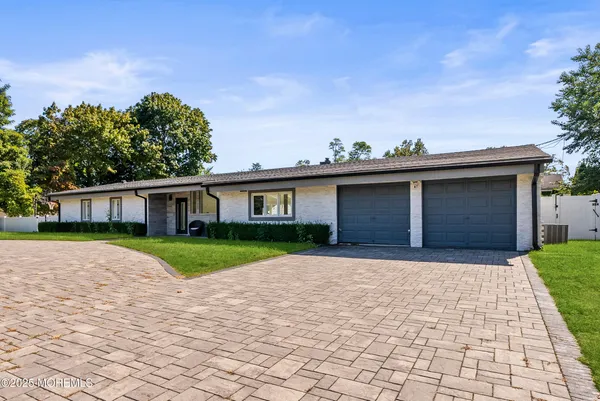 a front view of a house with a yard and potted plants