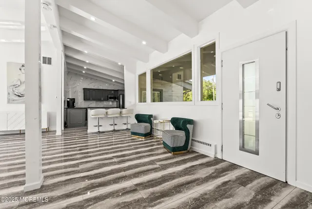 a living room with furniture a flat screen tv and large window