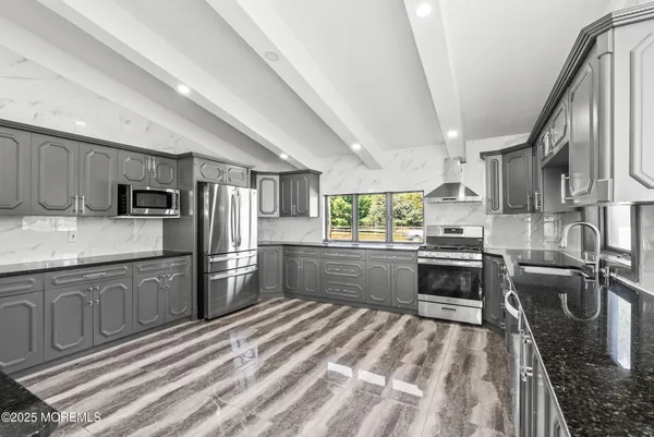 a kitchen with stainless steel appliances granite countertop a sink refrigerator stove microwave and stove