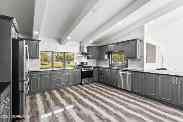 a kitchen with stainless steel appliances sink cabinets and window