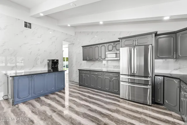 a kitchen with granite countertop a refrigerator and a sink