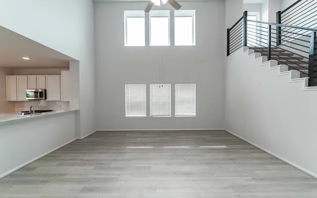 wooden floor in an empty room with a kitchen