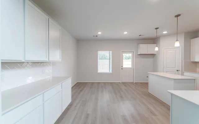 a large kitchen with stainless steel appliances granite countertop a stove top oven a sink dishwasher and a refrigerator