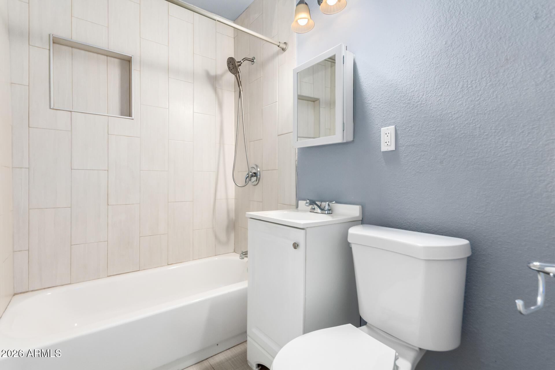 1636 East Whitton Avenue Phoenix, AZ 85016 - Photo 11 of 15 a white toilet sitting next to a bath tub