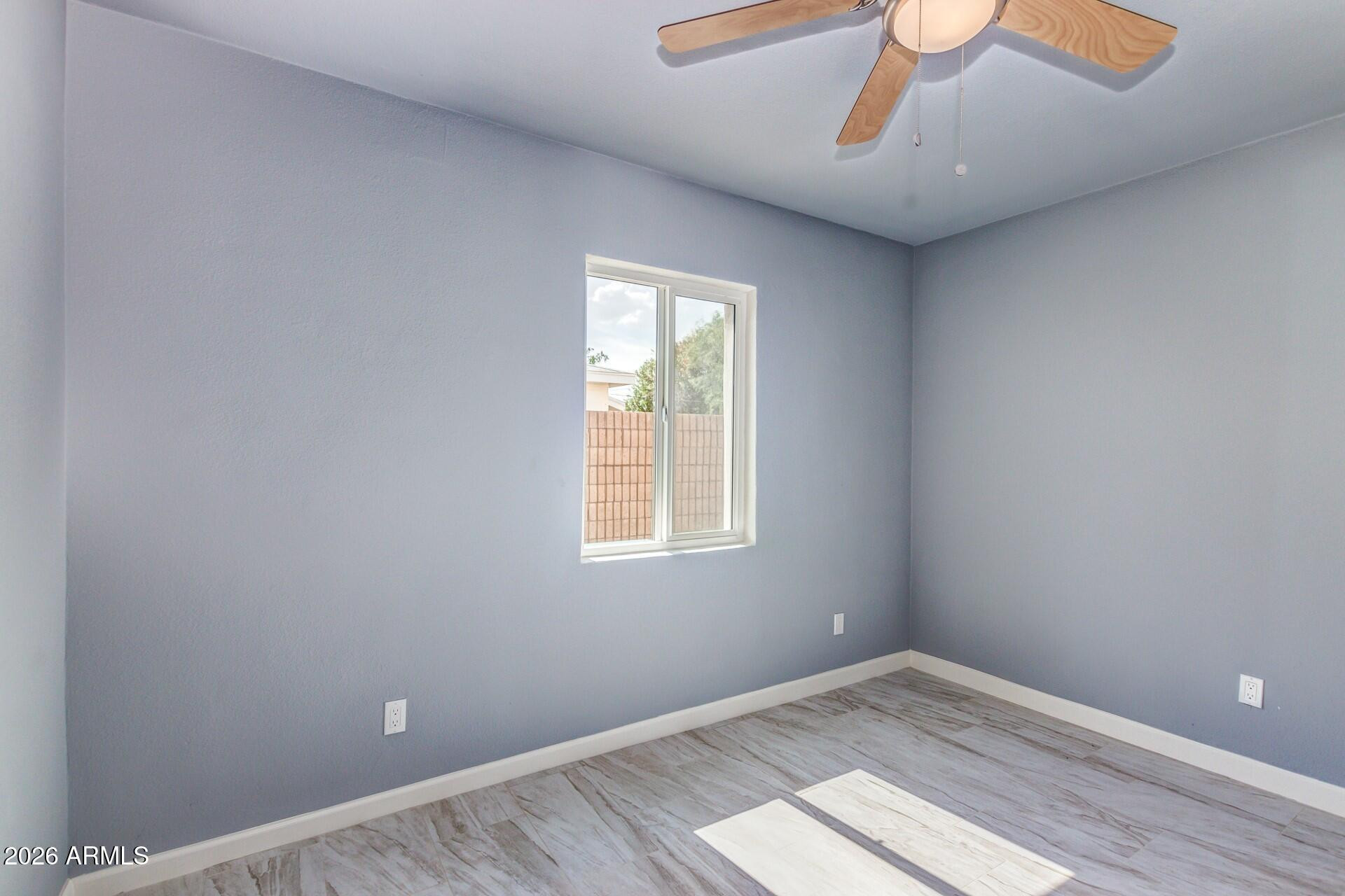1636 East Whitton Avenue Phoenix, AZ 85016 - Photo 5 of 15 a view of an empty room with wooden floor and a window