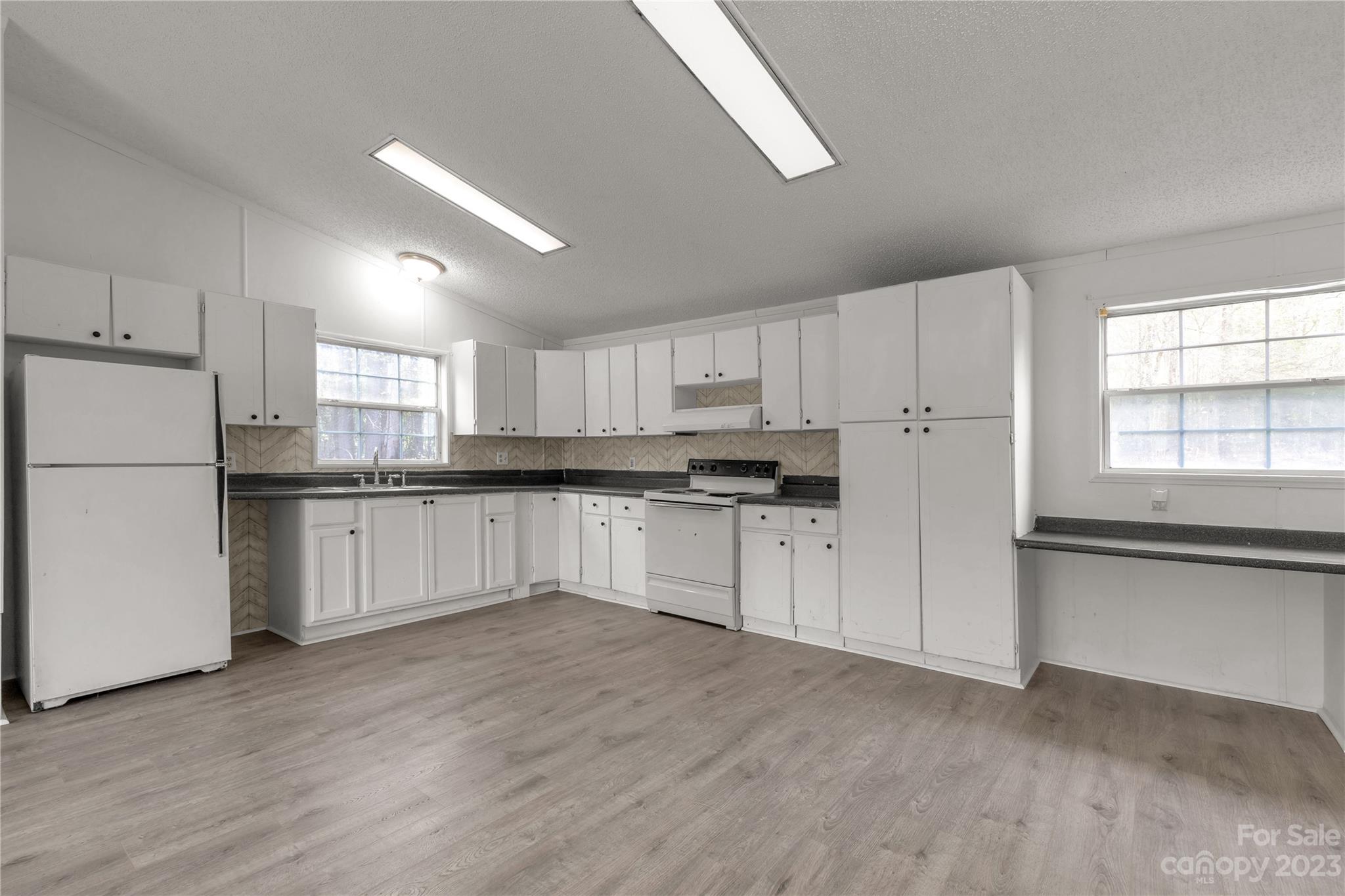 3678 Old Camden Road Heath Springs, SC 29058 - Photo 13 of 34 a kitchen with white cabinets and white appliances