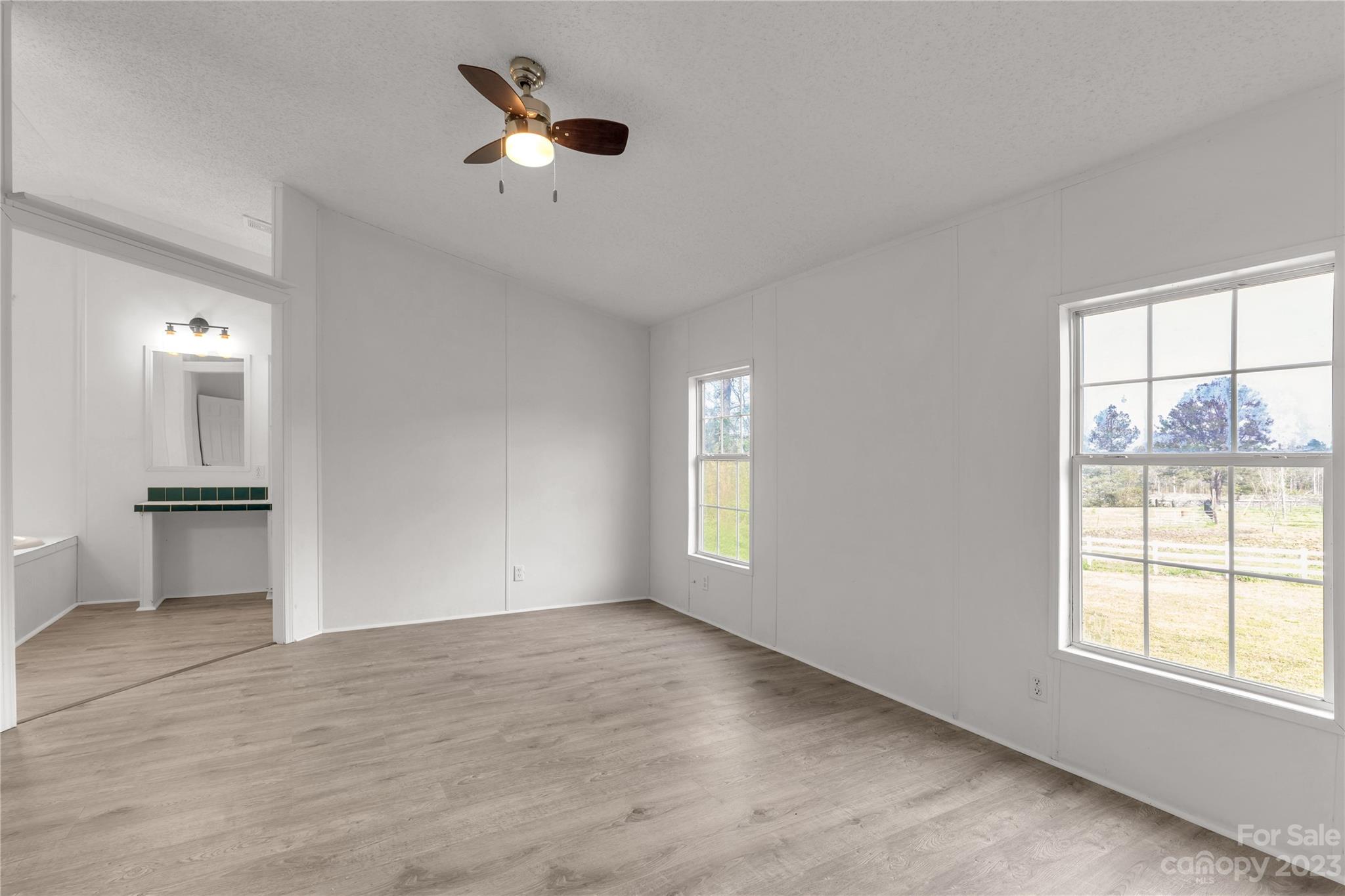 3678 Old Camden Road Heath Springs, SC 29058 - Photo 17 of 34 an empty room with windows and ceiling fan