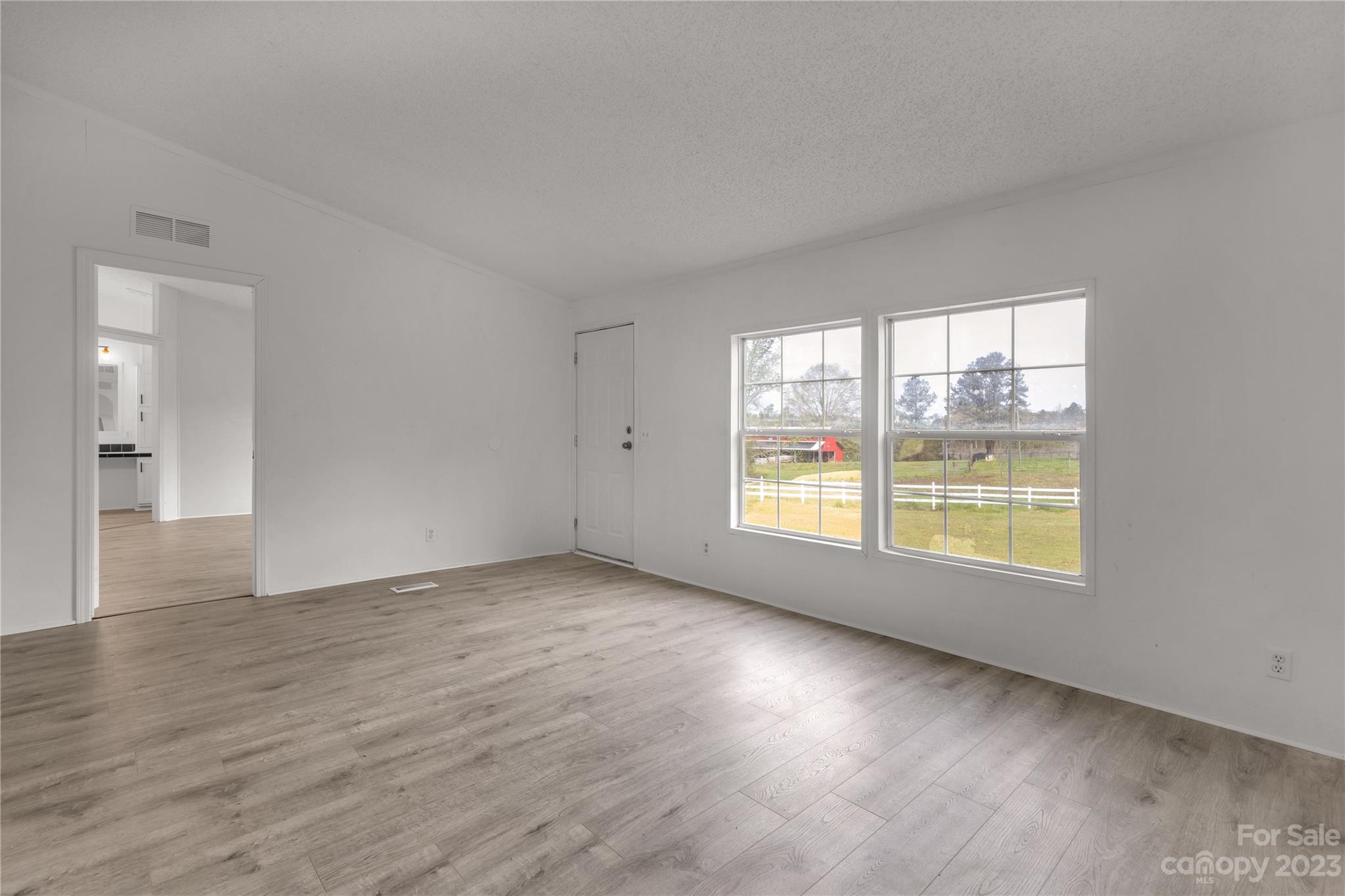 3678 Old Camden Road Heath Springs, SC 29058 - Photo 8 of 34 an empty room with wooden floor and windows