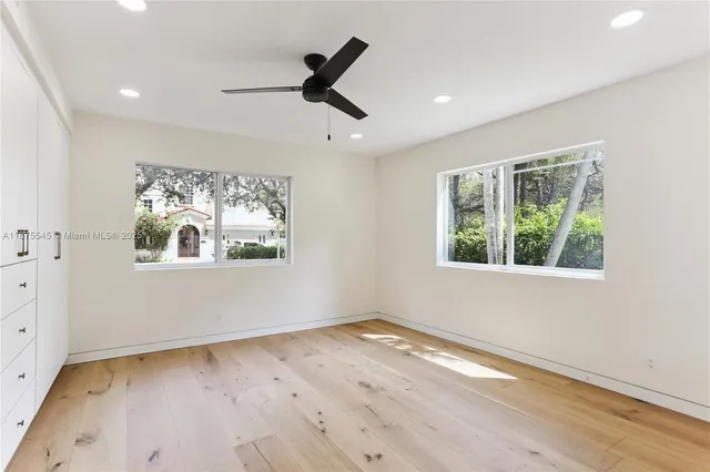 a view of empty room with wooden floor and window